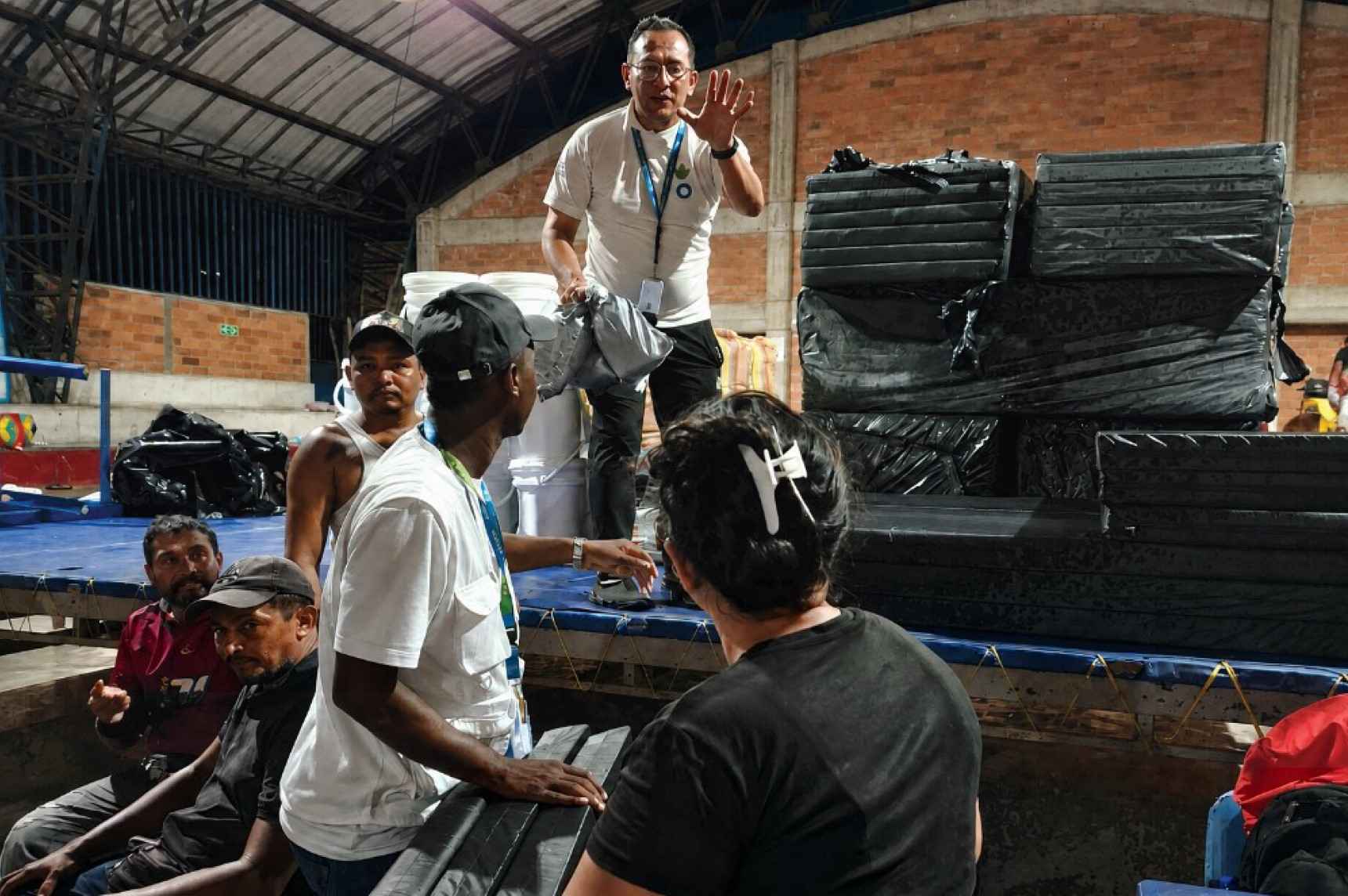 El equipo de Acción contra el Hambre distribuye kits familiares de alojamiento entre las personas acogidas temporalmente en el Coliseo de Quibdó, habilitado como albergue tras el terremoto, el 12 de agosto de 2026. © Acción contra el Hambre.